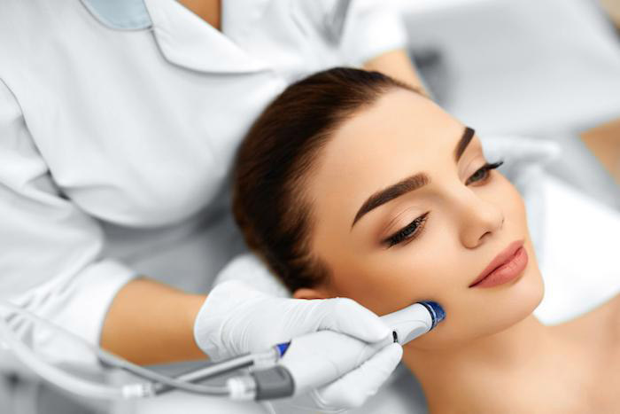 woman getting treatment done on face